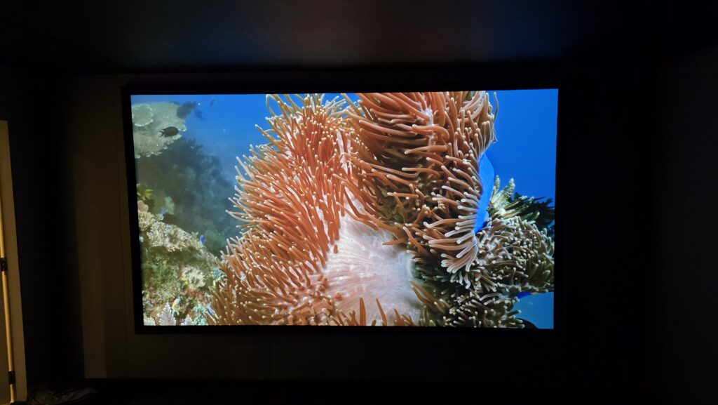 Home cinema screen displaying vivid content, showing the room in everyday use rather than just movie night